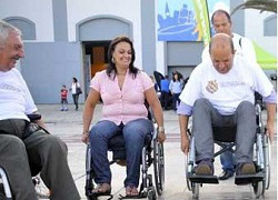 Fotografía de dos hombres y una mujer en silla de ruedas